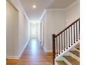 Inviting hallway featuring hardwood floors and a staircase with dark wood railings at 1673 Dover Creek Ln, Lawrenceville, GA 30045