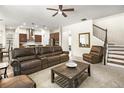 Cozy living room adjacent to kitchen featuring plush seating, staircase, and neutral color palette at 1318 Crestwind Nw Rd, Kennesaw, GA 30152