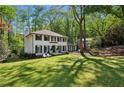 Charming two-story home with a landscaped yard and a classic white facade, surrounded by mature trees at 4505 Glengary Ne Dr, Atlanta, GA 30342