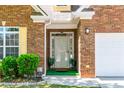 Close-up of the front door and entrance, featuring plants and yellow shutters at 8531 Spivey Village Trl, Jonesboro, GA 30236