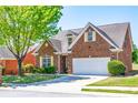 Attractive brick home with a manicured lawn, mature tree, and a two-car garage at 8531 Spivey Village Trl, Jonesboro, GA 30236