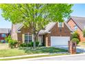 Charming brick home featuring a well-manicured lawn, mature tree, and a two-car garage at 8531 Spivey Village Trl, Jonesboro, GA 30236