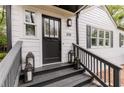 Charming home entrance featuring a black front door, gray stairs, and decorative lanterns at 308 Greenwood Ave, Decatur, GA 30030