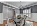 A stylish dining room with gray walls, white wainscoting, hardwood floors, and designer lighting at 3330 Camellia Ln, Suwanee, GA 30024
