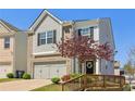 Charming home featuring a two-car garage, manicured lawn, and tree at 815 Regal Sw Ln, Atlanta, GA 30331