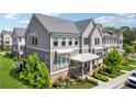 Angle view of an upscale townhome featuring neat landscaping, gray siding, and a silver metal roof at 2004 Cortland Rd, Milton, GA 30009