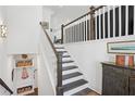 Bright foyer features a staircase with wooden and white rails and trim, and stylish wall decor at 2004 Cortland Rd, Milton, GA 30009
