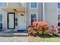 Charming townhome entrance with colorful flowering shrubbery by the front door, and siding in neutral colors at 1119 Riverbend Club Se Dr, Atlanta, GA 30339