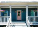 Inviting front porch showcasing hanging flower baskets and a stylish pink door at 22 Haygood Se Ave, Atlanta, GA 30315