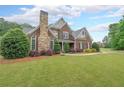 Attractive brick home boasts a stone chimney, well-kept lawn and beautiful shrubbery at 416 Battlefield Creek Dr, Marietta, GA 30064