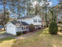View of two-story home and attached garage with mature trees and landscaping at 4347 Pleasant Ridge Rd, Decatur, GA 30034