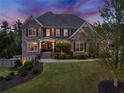 Elegant brick home illuminated at twilight, showcasing its inviting facade and manicured landscape at 903 Shaftoe Nw St, Kennesaw, GA 30152