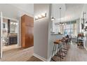 Open floor plan of Kitchen leading to Living Room with breakfast bar and modern lighting fixtures at 943 Peachtree Ne St # 2002, Atlanta, GA 30309