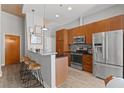 Modern kitchen with stainless steel appliances, granite counters, breakfast bar, and wooden cabinets at 943 Peachtree Ne St # 2002, Atlanta, GA 30309
