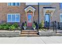 Inviting townhouse front door with brick steps, black iron railings and a charming covered entrance at 6065 Cushing Cir, Norcross, GA 30071