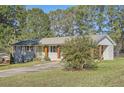 An inviting exterior featuring a light grey brick facade, a lime green front door, and a well-maintained lawn at 2376 Falls River Dr, Lithia Springs, GA 30122