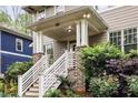 Inviting covered front porch with brick accents and manicured landscaping, creating a welcoming entryway at 286 Norwood Ne Ave, Atlanta, GA 30317