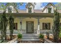 Inviting front porch with brick accents, classic columns, and a well-manicured landscape at 299 Saint Marys Nw Ln, Marietta, GA 30064