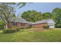 Lovely brick home featuring a lush front lawn and mature trees at 1766 Scholar Dr, Lawrenceville, GA 30044