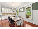Bright dining room with a modern chandelier, dark wood floors, and wainscoting at 2580 Defoors Ferry Nw Rd, Atlanta, GA 30318