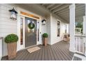 Inviting front porch with stylish decor, including potted greenery and a wreath on the front door at 2580 Defoors Ferry Nw Rd, Atlanta, GA 30318