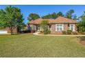 Beautifully landscaped front yard with mature trees and a charming brick home at 3230 Letha Woods Dr, Conyers, GA 30094