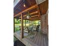 Inviting covered patio with wood ceiling, string lights, comfortable seating, and stylish outdoor rug at 4715 Howard Dr, Powder Springs, GA 30127
