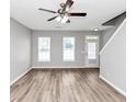 Bright living room features new gray paint, a ceiling fan and beautiful laminate flooring at 6252 Shenfield Ln, Union City, GA 30291