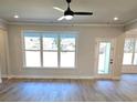 Sunlit living room with sleek ceiling fan, hardwood floors, and views to the backyard at 1715 Crumbley Rd, Mcdonough, GA 30252
