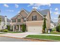 Charming two-story home featuring an attached garage, manicured front lawn, and attractive exterior details at 681 Deer Springs Way, Loganville, GA 30052