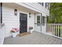 Cozy front porch featuring stylish lighting, potted pink flowers and painted wood at 3905 Mill Glen Dr, Douglasville, GA 30135