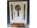 Elegant white front door with decorative glass and a floral wreath, creating a warm welcome at 5830 Wills Wood Cir, Cumming, GA 30040