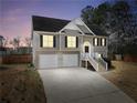 Two-story home with attached garage, well-lit with many windows, set against a night sky at 8870 Dornoch Cir, Winston, GA 30187