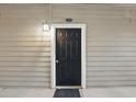 Close-up of the black front door of unit 1110 with a charming overhead light at 1250 Parkwood Circle Se # 1110, Atlanta, GA 30339