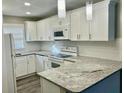 Bright kitchen featuring white cabinets, granite countertops, modern appliances, and a stylish backsplash at 2961 Stone Mountain St, Lithonia, GA 30058