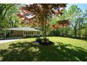 Quaint home with a lush green lawn and mature trees at 343 Ridge Pine Dr, Canton, GA 30114