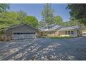 Ranch style home with a large driveway, attached garage, and mature trees at 3563 Castleridge Dr, Tucker, GA 30084