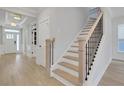 Bright entryway featuring light wood floors, white trim, and a staircase with black iron railings at 159 Sunshower Rdg, Canton, GA 30114