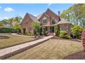A beautiful brick home with a manicured lawn and lush landscaping creates a welcoming atmosphere at 4030 Palisades Main Nw, Kennesaw, GA 30144