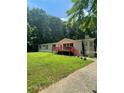 Inviting single-story home with a spacious front yard, front deck, and mature trees at 6650 George Ct, Cumming, GA 30041