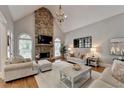 Inviting living room features a stone fireplace, high ceilings, neutral colors, and ample seating at 7050 Redcliff Ct, Suwanee, GA 30024