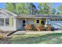 Inviting front entrance with yellow shutters, blue door, and manicured landscaping at 1132 Owen Cir, Sugar Hill, GA 30518