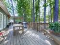 Spacious wooden back deck with a pergola, wooden railing, outdoor furniture, and forest view at 1017 Fairway Valley Dr, Woodstock, GA 30189