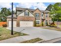 Charming two-story brick home boasts a three car garage and manicured landscaping at 1304 Slate Bend Dr, Dacula, GA 30019