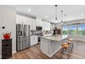Modern kitchen featuring stainless steel appliances, an island with bar seating, and stylish pendant lighting at 243 Commons Ave, Woodstock, GA 30188