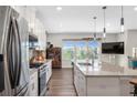 Bright kitchen with stainless steel appliances, granite countertops, island, and hardwood floors at 243 Commons Ave, Woodstock, GA 30188
