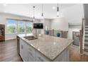 Kitchen island with stainless steel sink, granite counters and faucet with staircase and window view at 243 Commons Ave, Woodstock, GA 30188
