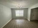 The dining room has laminate floors, a window, and a charming chandelier at 4884 Browns Mill Ferry Rd, Lithonia, GA 30038