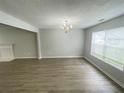 Bright living room features lovely laminate floors, neutral paint, and lots of natural light at 4884 Browns Mill Ferry Rd, Lithonia, GA 30038