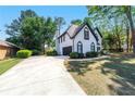Beautiful side view of home, with a long driveway leading to the garage, and manicured landscaping at 4161 Sherwood Oaks Dr, Decatur, GA 30034